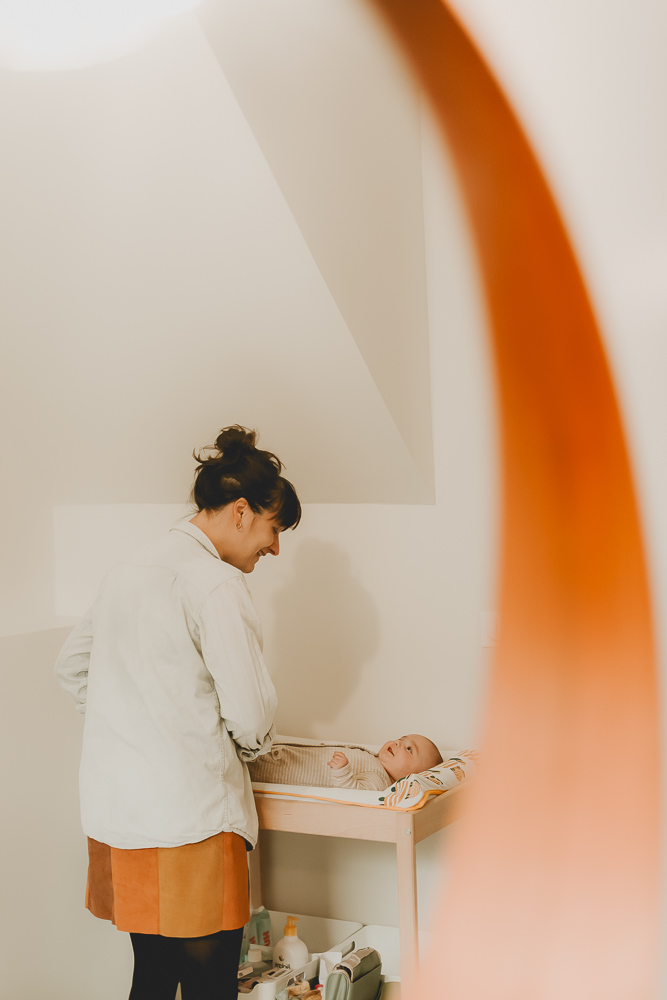 seance photo lifestyle bébé qui rigole pendant que maman le change
