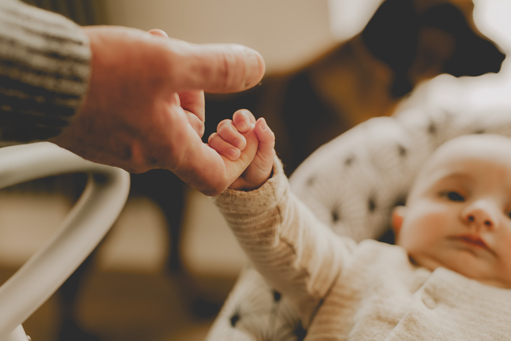 petite mains de bébé accroché aux doigts de son papa