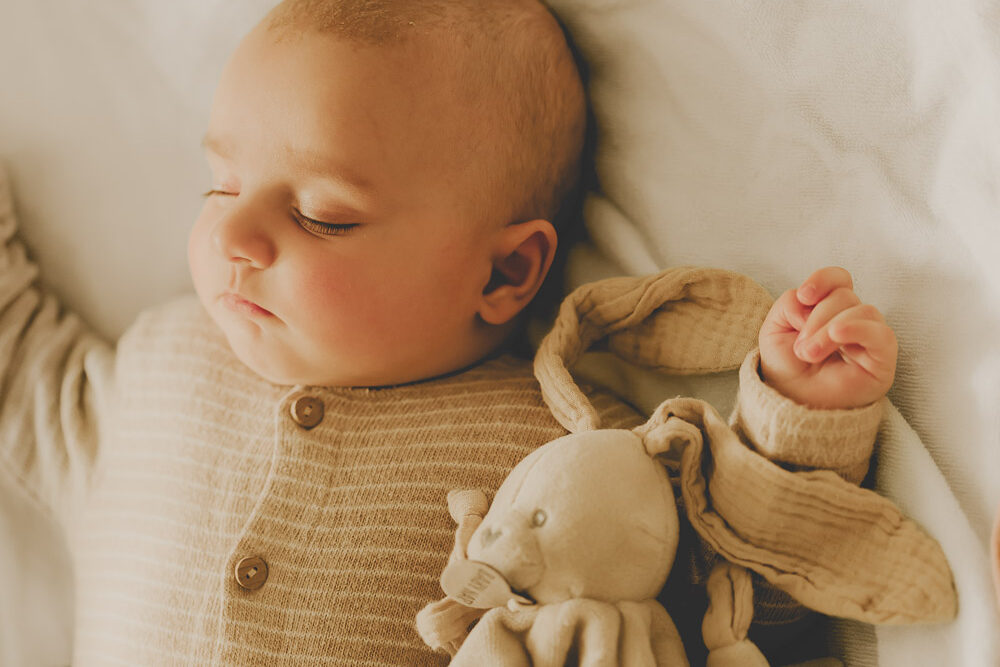 portrait de bébé paisible qui dort avec son doudou tendre
