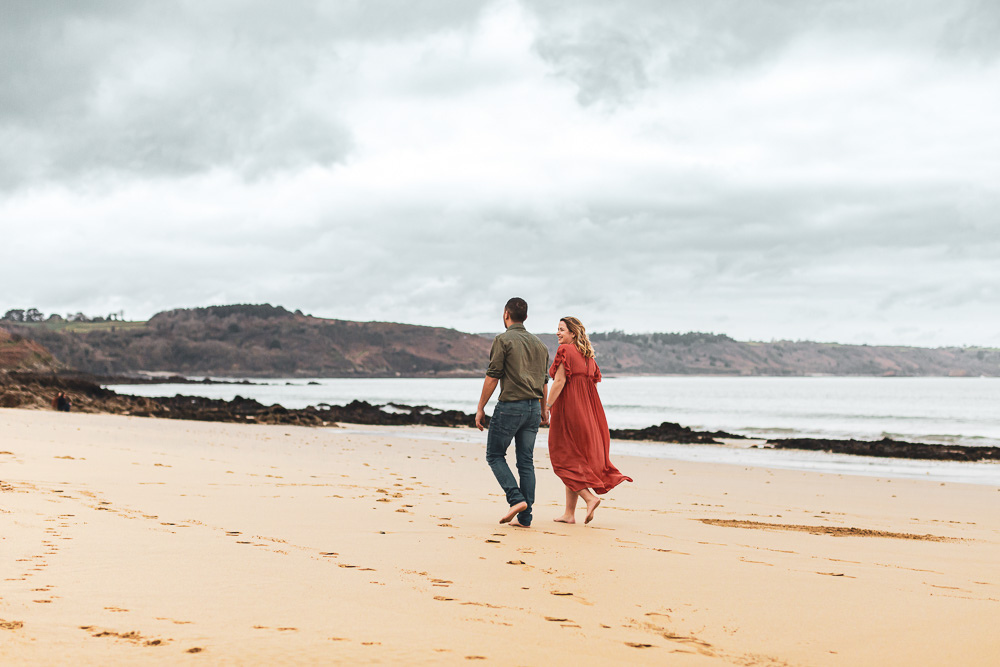 couple joyeux se balade a la plage grossesse